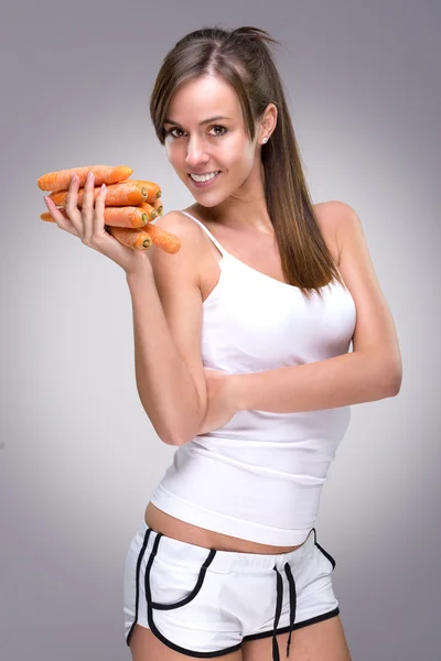 Красивая женщина держит морковь — стоковое фото
