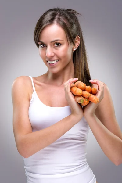 Beautiful woman holding carrot — Stock Photo, Image