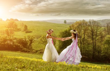 bir çayır üzerinde iki güzel gelin