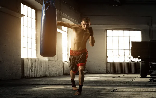 Jovem treino de boxe em um prédio antigo — Fotografia de Stock