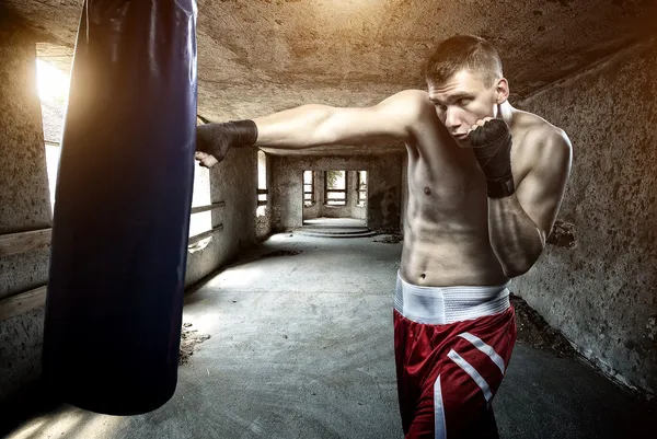Jovem treino de boxe em um prédio antigo — Fotografia de Stock