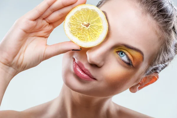 Красивая женщина с лимоном и желтым макияжем — стоковое фото