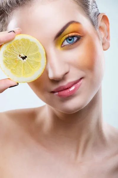 Hermosa mujer con limón y maquillaje amarillo —  Fotos de Stock