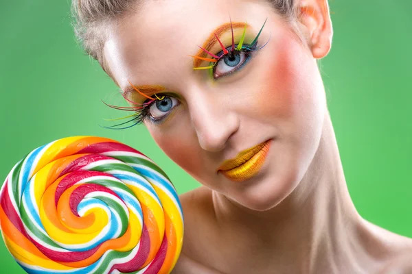 Extremt kommer vackra färgglada lollipop, med matchande smink Stockfoto