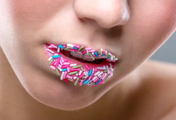 Vrouw mond vol van snoepjes — Stockfoto