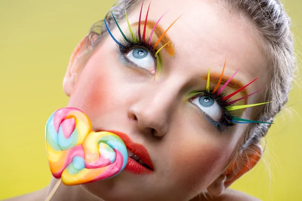 Woman with lollipop and extreme makeup — Stock Photo, Image