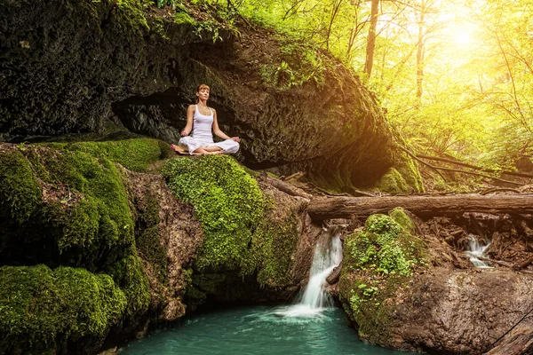 Kvinna utövar yoga Stockbild