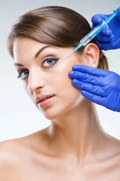 Beautiful woman face with hypodermic needle — Stock Photo, Image