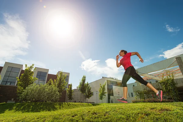 运行的女人在户外，在建筑物后面 — 图库照片