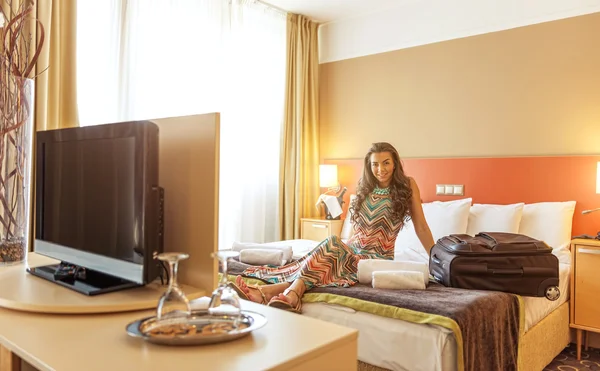 Mulher na cama de um quarto de hotel — Fotografia de Stock