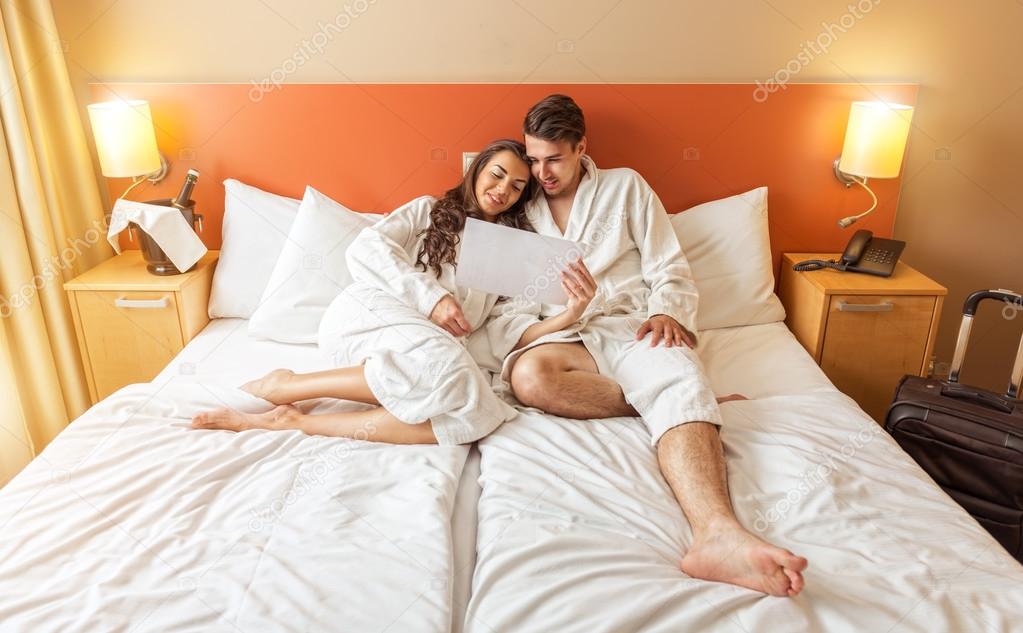 Young Couple lying in the bed of a hotel room