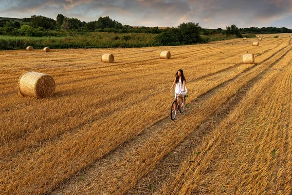 Kvinna cykling i vete fält — Stockfoto