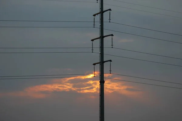  2015 ilkbaharında, bir şehrin günbatımı parlıyor. Batan güneşin ardından parlayan telefon direklerinin siluetleri.