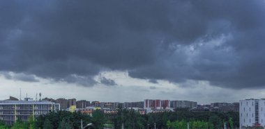Akşam, gökyüzünde çok sayıda bulut toplandı; bulutlar gökyüzünde muhteşemdi ve altındaki binalar çok küçüktü..