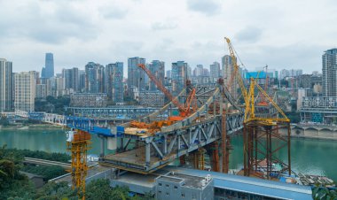 This is Chongqing, China, where a bridge is being built over the Jialing River to connect the two sides of the river.This is a bridge under construction and a stop for public transportation.