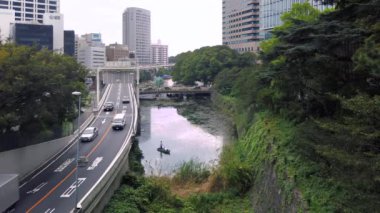 Tokyo, Japonya - 14 Eylül 2021: Kioich bölgesindeki Benkeibashi Köprüsü 'ne bakan Akasaka Metropolitan Otoyolu' ndaki Benkei hendeğinde balık tutan insanların statik videosu.