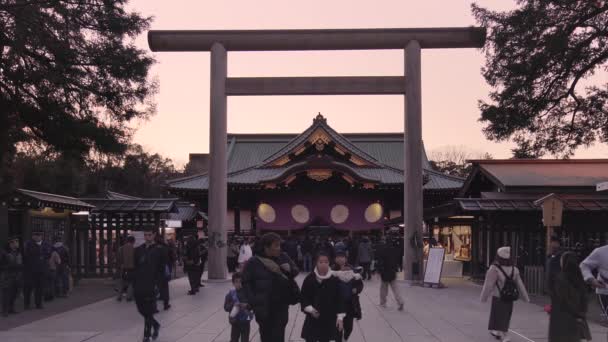 tokyo, Japonsko - leden 02 2020: Video japonců, kteří se scházejí v hlavním sále hondenu svatyně Jasukuni s výhledem na velkou bránu Shinmei Ootorii s kněžkou shinto miko během silvestrovských rituálů.