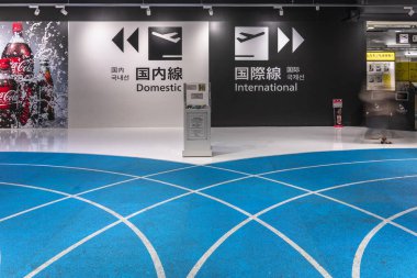 Tokyo, Japonya - Aralık 06 2020: Uluslararası ve yurt içi uçuşlara giden oklar ve simgeler Narita Uluslararası Havalimanı 'nın duvarındaki mavi bir patika kapısı..