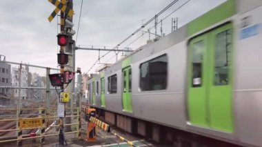Tokyo, Japonya - 25 Kasım 2021: Komagome yakınlarındaki Nakazato Demiryolu 2 adlı demiryolu kavşağından son sürat geçen bir E235 serisi treniyle Yamanote hattının görüntüsü.