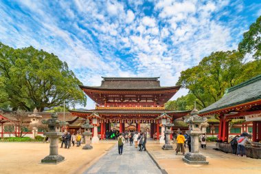 Tokyo, Japonya - Aralık 07 2019: Fukuoka ilindeki Japon Dazaifu tapınağının iki katlı Romon kapısına giden kasuga taşından fenerlerle çevrili kumda yürüyen turistler