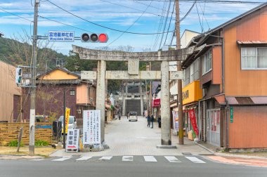 Kyushu, Japonya - 07 Aralık 2019: Japon shintoist Miyajidake Shrine Sand Shopping caddesinin girişindeki Stone Torii portalı İmparatoriçe Jingu 'ya adanmış ışıkların Yolu adlı merdivenlere çıkıyor..
