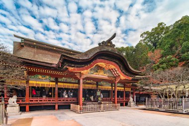 kyushu, fukuoka - Aralık 07 2019: Japon Dazaifu türbesindeki honden adlı Shintoist ana salonu karahafu adı verilen kıvrımlı bir çatı ve kapalı koridordaki turistlerle süslenmiştir..