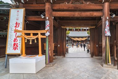 Kyushu, Japonya - 08 Aralık 2021: Miyajidake Tapınağı 'ndaki Ooshime matsuri sırasında Shimenawa adı verilen kurumuş samanla süslenmiş bir torii kapısının tahta minyatür kopyası..
