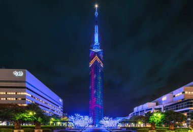 kyushu, fukuoka - Aralık 06 2021: Japonya 'nın en yüksek sahil kulesinin gece manzarası, Ayna Yelkenlisi adı verilen Fukuoka Kulesi hediye kurdeleleri, kar yıldızları ve xmas ağaçlarının resmedildiği yılbaşı sırasında aydınlatıldı