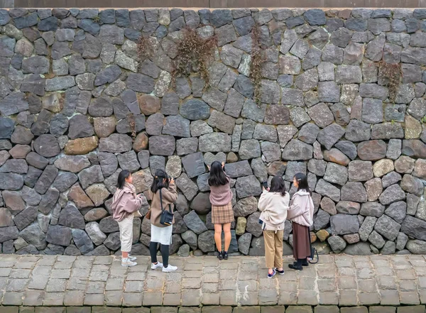 2021年12月12日 年轻的游客女孩们在靠近Megane或Spectacles Bridge的Nakashima河岸上的一块心形石头前拍照祈祷永恒的爱情 — 图库照片