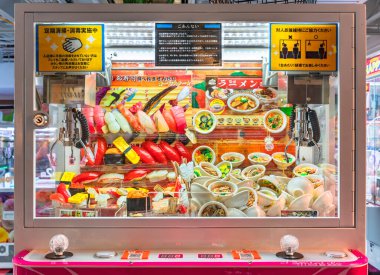 tokyo, japan - august 06 2022: Japanese claw crane called also UFO Catcher full of key holders depicting realistics sushi and ramen noodles bowls in a game center of Nakano Broadway Shopping Mall.