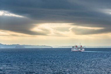 Chiba, japan - 25 Aralık 2021: Kanayamaru feribot gemisi Uraga kanalı üzerinde Kanaya limanına doğru ilerliyor Boso yarımadasının kıyıları boyunca sabah vakti fırtınalı bir gökyüzünün altında..