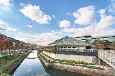 Nagasaki, kyushu - 12 Aralık 2021: Oura Kaigan sokağı boyunca uzanan Orandasaka Köprüsü ile Nagasaki Civic Hall 'un Waterfront Park restoranı ve Şaraphanesi çevresindeki kanal veya hendek.
