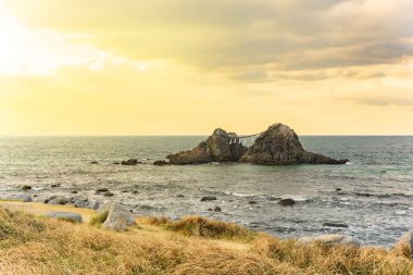 Itoshima sahili ve ünlü tarihi Sakurai Futamigaura 'dan Meoto Iwa çift kayaları Fukuoka denizinde kutsal bir Shinto saman ipi ile korunuyor..