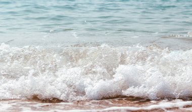 White foam of the sea at sandy beach