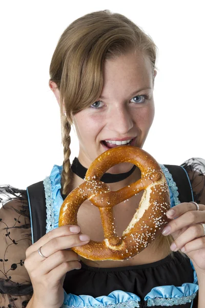 Bavarian girl eating a pretzel. — стокове фото