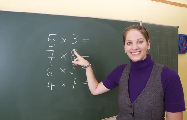 Young teacher in front of a blackboard — Stock Photo, Image