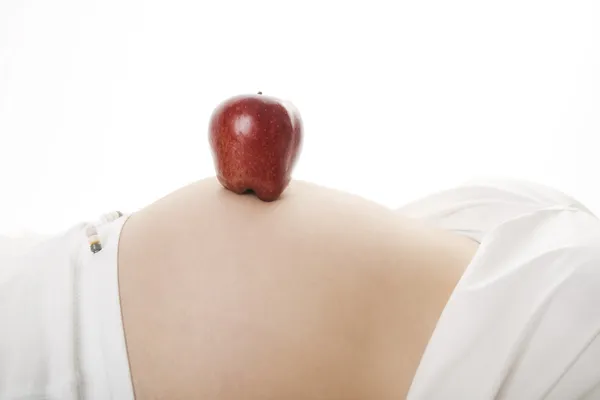 Manzana en el vientre embarazada — Foto de Stock