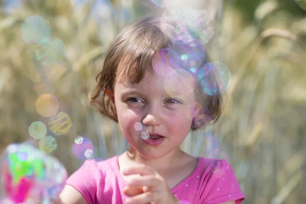 Kleines Mädchen mit Seifenblasen Stockfoto