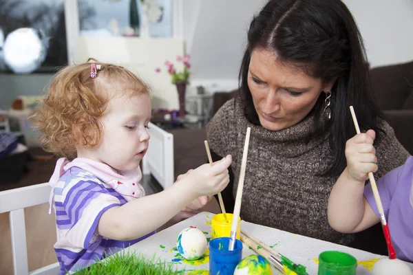 Mother painting easter eggs with children — Stock Photo, Image