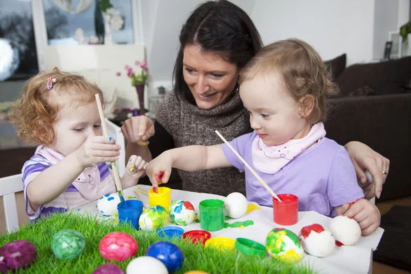 Madre che dipinge uova di Pasqua con bambini — Foto Stock