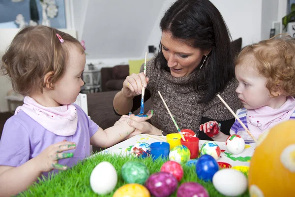 Mère peignant des œufs de Pâques avec enfants — Photo