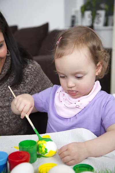 Mãe pintando ovos de Páscoa com filha Fotografia De Stock