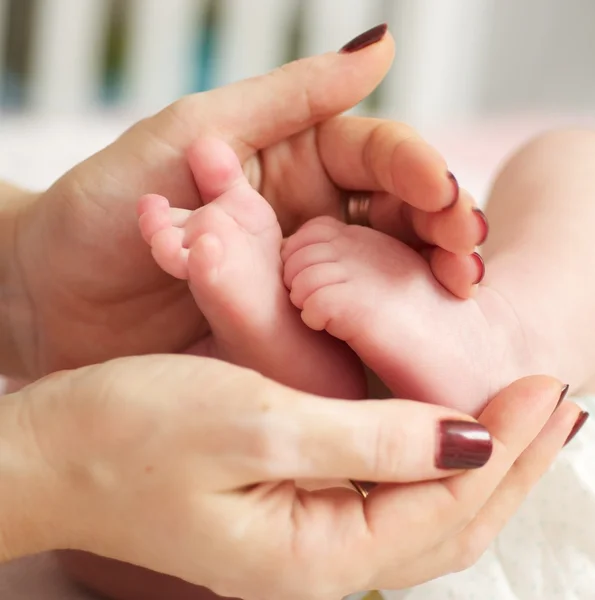 Мать держит ножки новорожденных — стоковое фото
