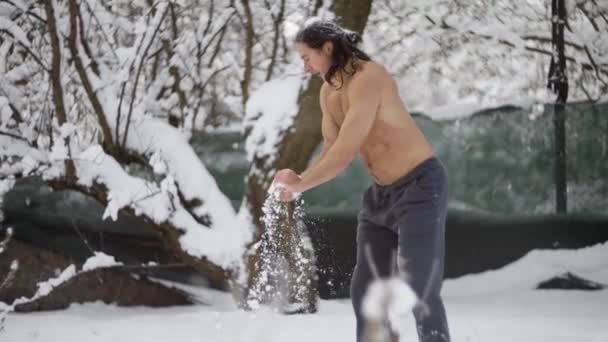 Egy férfi atléta, levetkőzve a hóban, keményedik. — Stock videók