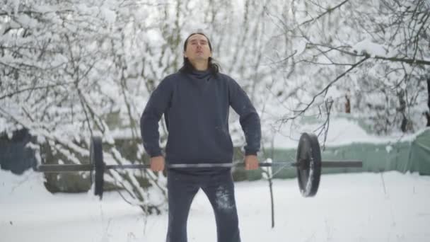 Man is an sportsman, with long black hair, is engaged in weightlifting, slow motion — стоковое видео