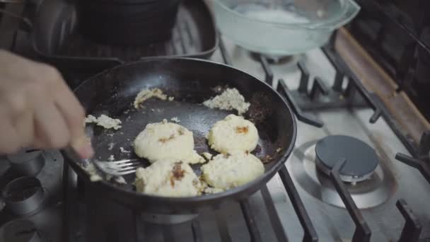A woman in the kitchen, her pancakes are burnt, she rips a pancake from a frying pan — Stockvideo