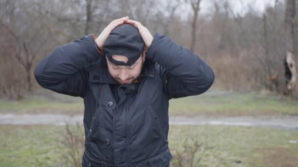 Ein Mann in schwarzer Jacke und Mütze rastete in der Natur aus und machte ein Picknick — Stockvideo