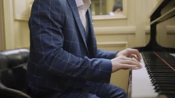 美しいスーツに身を包んだ男がピアノを演奏する — ストック動画