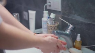 Kız yatmadan önce ellerini yıkar ve yüzünü yıkar. Yüksek kalite 4k görüntü