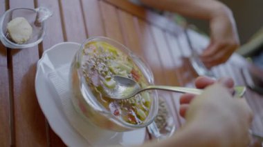 A woman has lunch in a vegetarian canteen, eats delicious vegan soup, slow motion, close-up,. High quality 4k footage